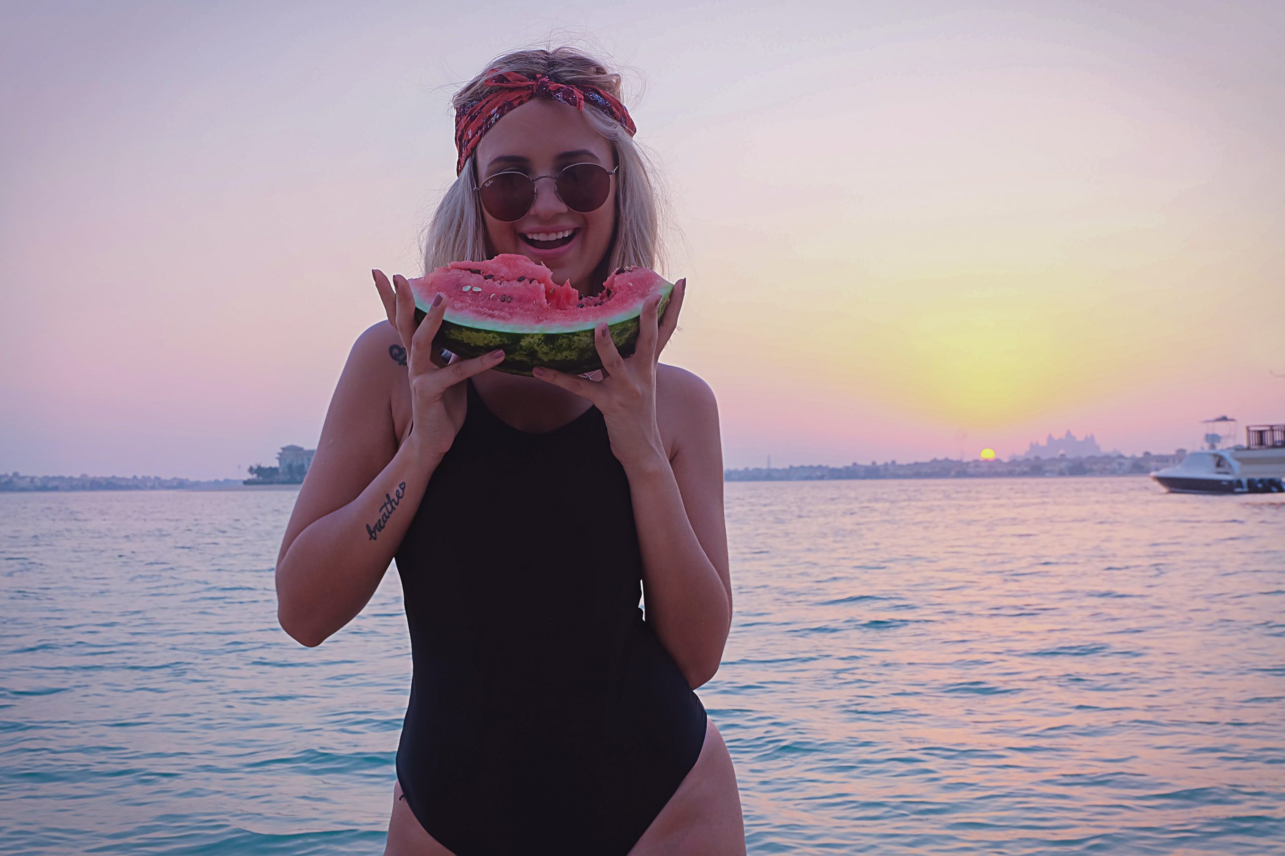 Frau mit Wassermelone in der Hand, dabei lächelnd