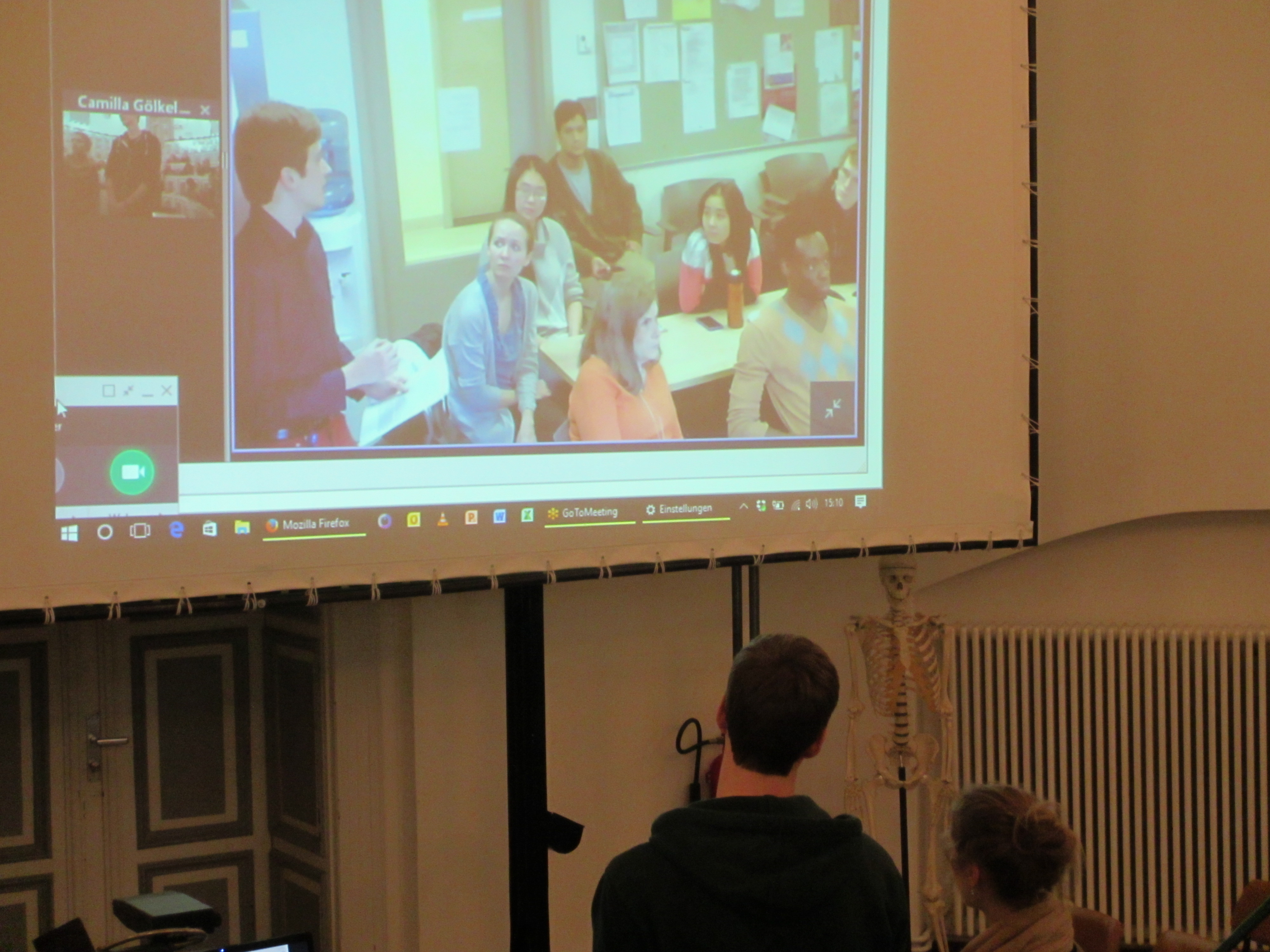 Benjamin Tropper und Charlotte Ehl halten ihre Präsentation über die Leinwand zusammen mit Studierenden aus New York. 